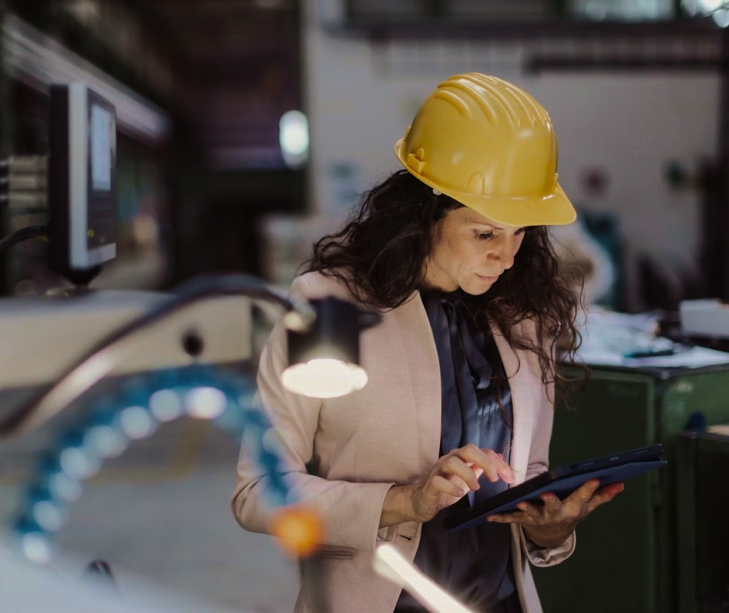 Engineer in a hard hat reviewing data on a tablet