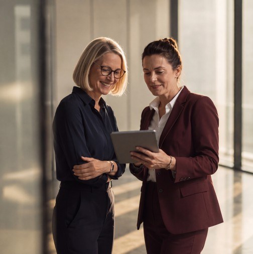 Two advisors reviewing a tablet